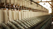 Spools of thread on machinery in textile mill. Spools of thread on machinery in textile mill.