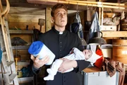 Maik (Daniel Donskoy) versucht das Baby zu beruhigen und bittet um göttlichen Beistand.
