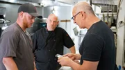 Chef Robert Irvine talks with Blake, son of Mark/ sous chef at Steak N' Stuff, in the kitchen of the restaurant. They are joined by Mark Lelushce, owner of Steak N' Stuff; as seen on Food Network's Restaurant:Impossible Season 20. Chef Robert Irvine talks with Blake, son of Mark/ sous chef at Steak N' Stuff, in the kitchen of the restaurant. They are joined by Mark Lelushce, owner of Steak N' Stuff; as seen on Food Network's Restaurant:Impossible Season 20.