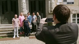 Beim Klassentreffen stellen die Ehemaligen das Klassenfoto vor ihrer Schule nach.