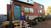 Chad smiles and poses for the camera on the front steps of his completed tiny home, equipped with many smart and automated technology features, in Plano, Texas, as seen on Tiny House, Big Living.