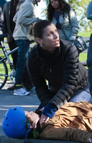 Schafft es Erin (Bridget Moynahan, knieend) den nach einem Fahrradunfall verletzten Sean (Andrew Terraciano, liegend) zu stabilisieren, bevor der Notarzt kommt?