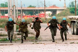 Sarajevo, Bosnien, 1994: Franz&ouml;sische und ukrainische UN-Soldaten fl&uuml;chten, als serbische Scharfsch&uuml;tzen das Feuer auf sie in der Innenstadt Sarajevos er&ouml;ffnen.