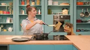 Maya zeigt Moppi, wie sie die Brote in der Pfanne brät.