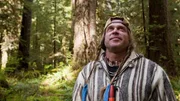 USA, Washington, Olympic National Forest, Cody Lundin walking through Pacific Northwest rainforest during Dual Survivor filming