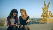 Lena (Jessica Lord, r.) hat Ines (Eubha Akilade, l.) zu sich aufs Dach der Oper geholt. Sie hofft, dass Ines eine Idee hat, wie sie wieder zurück ins Jahr 1905 kommen kann. Die beiden schreiben deshalb gemeinsam einen Brief an Henri, der im Jahr 1905 fest sitzt und ihnen Informationen zu Zeitreisen zukommen lassen soll.