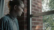 A woman looks out the window.