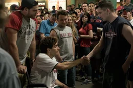holding a wheelchair: Big D (Nate Richman), sitting: Jeff Bauman (Jake Gyllenhaal)