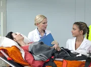An Dr. Isabel Dahls (Denise Zich, mi.) erstem Tag als neue Ärztin der Sachsenklinik wird Aylin Demir (Suzan Demircan, li.) mit einem Oberschenkelbruch eingeliefert. Zusammen mit Schwester Arzu Ritter (Arzu Bazman, re.) übernimmt Isabel die Erstversorgung.