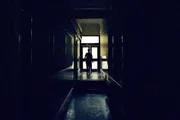 Amy walks down a dark corridor.
