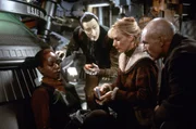 Captain Picard (Patrick Stewart, r.), Commander Data (Brent Spinner, M.) und Dr. Beverly Crusher (Gates McFadden, 2.v.r.) k&uuml;mmern sich um die verletzte Lily Sloane (Afre Woodard, l.).