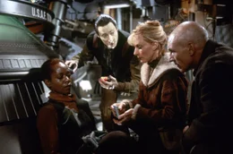 Captain Picard (Patrick Stewart, r.), Commander Data (Brent Spinner, M.) und Dr. Beverly Crusher (Gates McFadden, 2.v.r.) k&uuml;mmern sich um die verletzte Lily Sloane (Afre Woodard, l.).