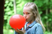Franzi (Mia Löffler, KLD) zieht an einem mit Lachgas gefüllten Ballon.