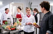 Kilian (Anthony Paul, r.) versichert Greta (Laura Osswald, m.), dass er sein exklusives Menü auch für eine Hochzeitsgesellschaft kochen kann. Kilian (Anthony Paul, r.) versichert Greta (Laura Osswald, m.), dass er sein exklusives Menü auch für eine Hochzeitsgesellschaft kochen kann.