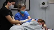 Dr. Sandra Lee performs surgery on James T. back cysts with her assistant, Janet C.