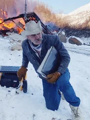 Marty versucht, alte Fotoalben zu retten, w&auml;hrend sein Haus hinter ihm abbrennt.