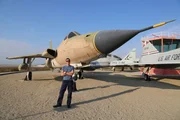 Sean stands in front of a fighter jet at NASA Armstrong