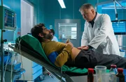 Razak Amari (Reza Brojerdi, li.) erzählt Dr. Roland Heilmann, was sich wirklich zugetragen hat, bevor er zu Hause zusammengebrochen ist.