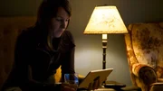 Heather looking at a tablet under the light. Heather looking at a tablet under the light.