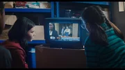 Monika (Lucy Chambers, r.) und Isabel (Alis Waters, l.) haben es geschafft, einen Fernsehsender zu empfangen. Sie entdecken Maeve (Skye McClenaghan, TV. r.) in den Nachrichten. Während die Nachrichtensprecherin (Mwaka Mudenda, TV, l.) moderiert, wird Maeve im Hintergrund von Bea (Aoife Hughes, TV, M.) angesprochen. Monika (Lucy Chambers, r.) und Isabel (Alis Waters, l.) haben es geschafft, einen Fernsehsender zu empfangen. Sie entdecken Maeve (Skye McClenaghan, TV. r.) in den Nachrichten. Während die Nachrichtensprecherin (Mwaka Mudenda, TV, l.) moderiert, wird Maeve im Hintergrund von Bea (Aoife Hughes, TV, M.) angesprochen.