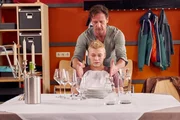Stefan Vollmer (Hendrik Duryn, oben) coacht Luis (Julius Nitschkoff) in Sachen Restaurant-Manieren, denn ausgerechnet der vulgäre Querulant Luis soll sich als aalglatter Verlagserbe Niklas ausgeben und Roses Schulführung loben.