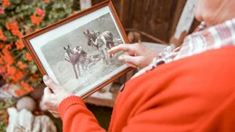 Irmgard Rabitsch zeigt ein historisches Foto von b&auml;uerlichen Arbeiten ihrer Familie.