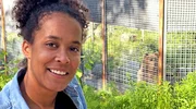 Pia steht im Ranua Zoo vor dem Bärengehege. Im Hintergrund sieht man Bärin Malla.