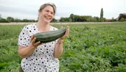 Bäuerin Cindy ist stolz auf ihre Zucchini-Ernte. Bäuerin Cindy ist stolz auf ihre Zucchini-Ernte.
