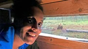 Pia in der Beobachtungshütte. Hinter ihr sieht man den Braunbären Yogi.