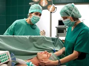 Dr. Elena Eichhorn (Cheryl Shepard, links) und Dr. Kathrin Globisch (Andrea Kathrin Loewig) können nicht mehr auf Jens' (Jeremias Koschorz, liegend) abgetrennten Arm warten. Sie müssen mit der OP beginnen.