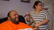 Abi in bed with wife Brenda standing over smiling 2