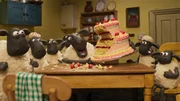 Die Schafe feiern den Geburtstag des Farmers und kosten von seiner Torte.