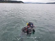 Ross Kemp und der Meeresarchäologe Mallory Haas an der Oberfläche, während sie sich darauf vorbereiten, an der möglichen Wrackstelle eines neu entdeckten Sklavenschiffwracks aus dem 17. Jahrhundert zu tauchen.