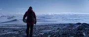 Overg&aring;rd (Mads Mikkelsen) inspiziert die Umgebung, aber ein Fu&szlig;marsch durch die lebensfeindliche Schneelandschaft kommt nicht in Frage.