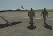 Zwei CBP-Agenten gehen auf einer Landebahn neben einem Flugzeug in Mayaguez, PR (Lucky 8 TV).