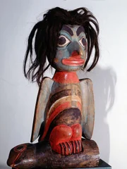 Gedenkskulptur des Eulenmanns. Der Legende nach wurde der Eulenmann um 1890 in Icy Bay von einem umstürzenden Baum erschlagen. Die Skulptur zeigt ihn mit einem Vogelkörper und einem menschlichen Kopf. Man nimmt an, dass sie aus dem Baumstamm geschnitzt wurde, der ihn getötet hatte, und bei Festen zu seinen Ehren verwendet wurde. Gedenkskulptur des Eulenmanns. Der Legende nach wurde der Eulenmann um 1890 in Icy Bay von einem umstürzenden Baum erschlagen. Die Skulptur zeigt ihn mit einem Vogelkörper und einem menschlichen Kopf. Man nimmt an, dass sie aus dem Baumstamm geschnitzt wurde, der ihn getötet hatte, und bei Festen zu seinen Ehren verwendet wurde.