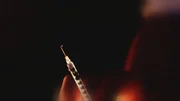 A needle drips out a liquid drug from the tip. A needle drips out a liquid drug from the tip.