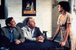 Der Schriftsteller Pablo Neruda (Philippe Noiret, M.) erschlie&szlig;t Mario (Massiomo Troisi) die Welt der Poesie. Dank ihm kann Mario auch die Zuneigung von Beatrice Russo (Maria Grazia Cucinotta) gewinnen, die er schon lange verehrt.