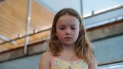 Sigrid (Maria Ross) steht allein auf dem Dreimeterbrett im Schwimmbad und möchte so gerne runterspringen.