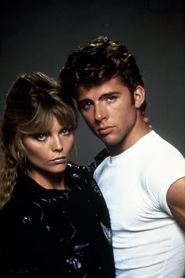 Es dauert nicht lange, bis sich Michael Carrington (Maxwell Caulfield, r.) in Stephanie (Michelle Pfeiffer, l.), die Anf&uuml;hrerin der 'Pink Ladies', hoffnungslos verknallt. Die aber steht nur auf knallharte Motorrad-Biker ...