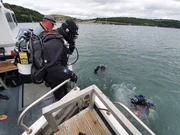 Ross Kemp bereitet sich darauf vor, sich seinem Tauchteam, der Meeresarchäologin Mallory Haas und seinem Tauchpartner Mark Culwick im Wasser anzuschließen. Plymouth Sound, Devon. August 2021. Photo by Nicki Meharg.