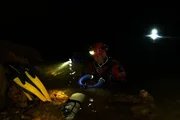Ein Mann erkundet die wasserreichen Bereiche in der Höhle. Ein Mann erkundet die wasserreichen Bereiche in der Höhle.