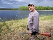 Charlie Wright looking around for the bear that's inhabited his trapping cabin site.