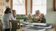 Familie Griessler am Mittagstisch beim spielen und lesen.
