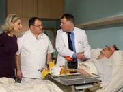 Als Dr. Heilmann (Thomas Rühmann, re.) zu Ingo Rottmann (Tobias Schulze, liegend) gerufen wird, findet er ihn ohnmächtig im Bett vor.  Dr. Heilmann stellt Pfleger Hans-Peter Brenner (Michael Trischan, mi.) zu Rede. Madeleine Hagen (Alexandra Seefisch) kommt nicht dazu, die Situation zu erklären.