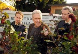 Nachdem jemand an seinem Rosenbusch zugange war, hat Frido Schulz (Robert Atzorn) seinen Sohn David (Janek Rieke, li.) nebst Kollegen alarmiert - schlie&szlig;lich sind diese bei der Polizei.