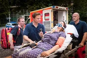Dr. Haase (Fabian Harloff, 2.v.l.) macht sich Sorgen. Er hat bei seiner Patientin (Elisabeth Baulitz) eine schwere allergische Schockreaktion diagnostiziert, doch ist noch unklar, worauf sie so stark reagiert hat.