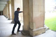 David Tong, theoretischer Physiker an der University of Cambridge, zeigt, dass die Säule, gegen die er schlägt, echt ist.