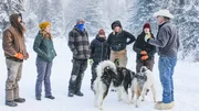 Marty (r.) unterh&auml;lt sich mit (v.l.n.r.) Matt, Katie, Maciah, Gauge, Misty und Mollee im Schnee, w&auml;hrend zwei Hunde in der N&auml;he sind.