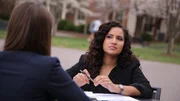 Fatima Silva listens to expert Dr. Stacy Wetmore at a park table. Fatima Silva listens to expert Dr. Stacy Wetmore at a park table.